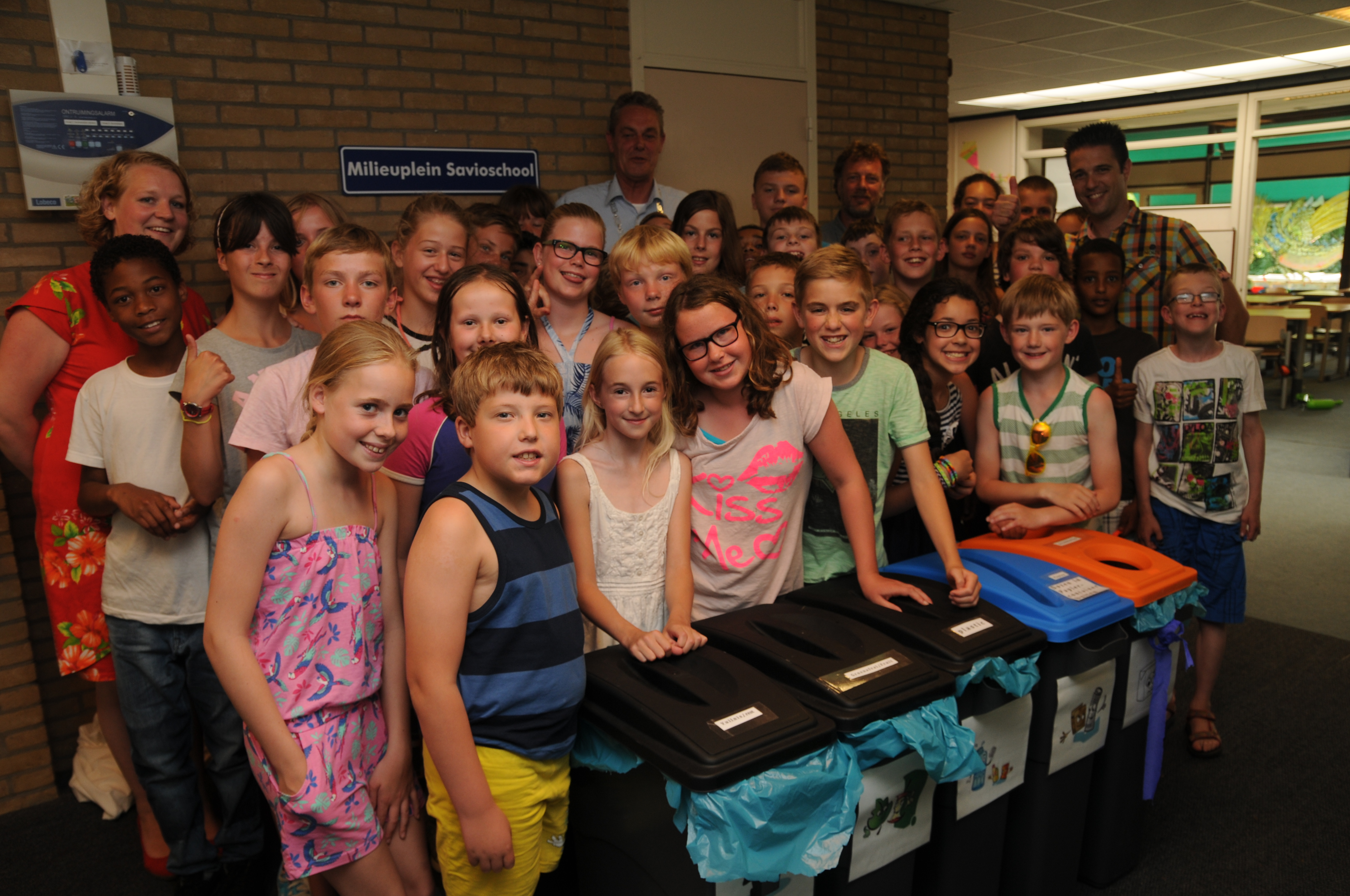 Kinderen van de Savioschool met de juf, Jeroen Spanbroek en wethouder De Jong bij het milieuplein